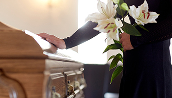 Person-holding-white-lilies-beside-a-casket.jpg